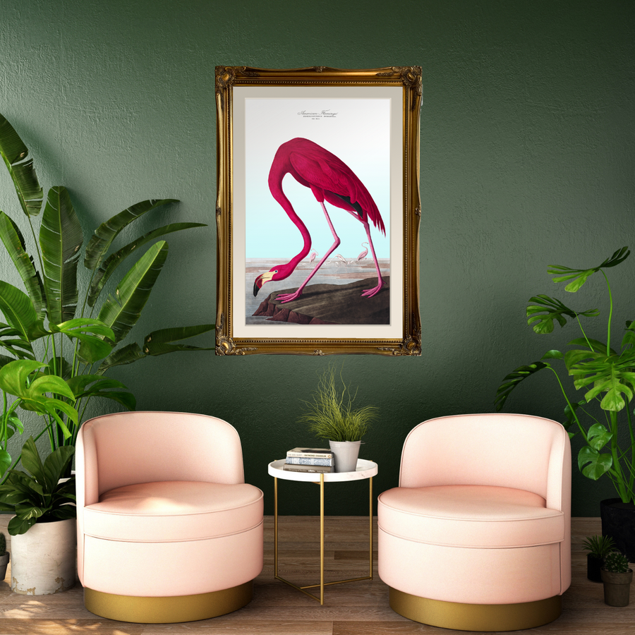 Flamingo in an ornate gold frame on a green wall with pink chairs 